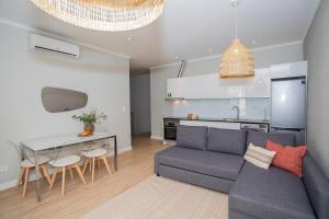 a living room with a couch and a table and a kitchen at Casa do Gaveto in Água de Pau