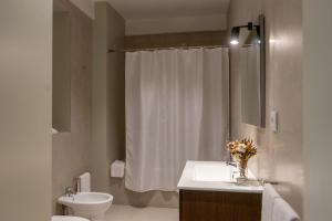 a bathroom with a sink and a toilet and a shower at Casa do Gaveto in Água de Pau