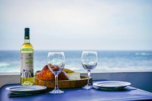 una mesa con dos copas de vino y una botella de vino en GuestReady - Beachfront Casa da Praia, en Porto Formoso 21 fotos más