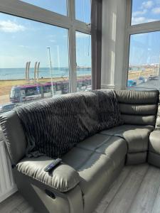 a leather couch in a room with a view of the ocean at Lynton apartments in Blackpool
