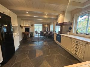 a large kitchen with a counter and a table at Sommerferie i skjærgårdsidyll på Langenes i Kristiansand in Kristiansand
