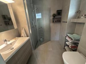 a bathroom with a shower and a sink and a toilet at Sommerferie i skjærgårdsidyll på Langenes i Kristiansand in Kristiansand