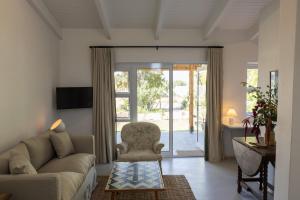 Stillewe Guest Cottages في Prince Alfreds Hamlet: غرفة معيشة مع أريكة وكرسي