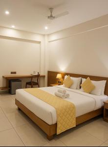 Un dormitorio con una cama grande y un escritorio. en Devalokam Grand, en Edappāl