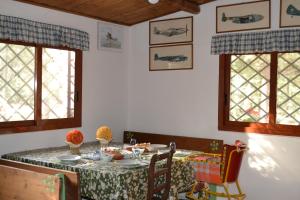a dining room with a table and two windows at B&B Le Stagioni in Castel del Monte