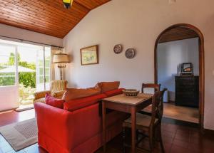a living room with a red couch and a table at GuestReady - Domus Adepta Charming w/ Garden in Furnas +15 photos