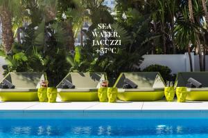 a group of chairs sitting next to a pool at Essence Hotel Boutique in Torremolinos