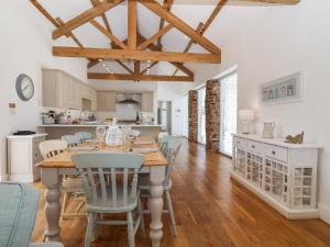 a kitchen and dining room with a table and chairs at Old Orchard Barn in Saltash