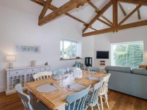 a dining room with a wooden table and chairs at Old Orchard Barn in Saltash