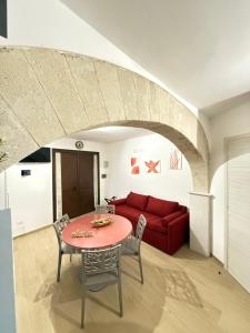 a living room with a table and a red couch at Custonaci 36 in Trapani