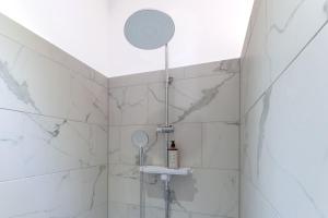 a bathroom with a shower with white marble walls at Lit Living - Luxury House - Box Spring - Parking - Exclusive Kitchen in Altenstadt