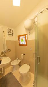 a bathroom with a toilet and a sink and a shower at Nel Cuore del Borgo in Vico del Gargano +17 photos