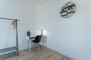 a desk and chair in a room with a wall at Lit Living - Luxury House - Box Spring - Parking - Exclusive Kitchen in Altenstadt