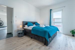 a bedroom with a bed with a blue blanket on it at Lit Living - Luxury House - Box Spring - Parking - Exclusive Kitchen in Altenstadt +77 photos