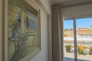 um quarto com uma janela com uma mesa e uma varanda em GuestReady - Marina view top floor with terrace em Ponta Delgada