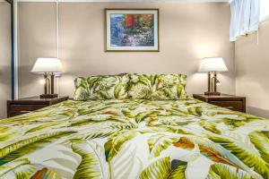 a bedroom with a large bed with two lamps at Kahana Reef 315 by Coldwell Banker Island Vacations in Kahana +36 photos