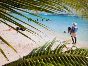 a group of people in the water at a beach at LE LAGON BLEU, BUNGALOWS Vue sur MER , 350 m de la plage in Sainte-Anne