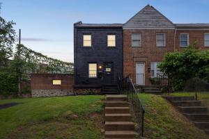 a black house with stairs leading to the front door at Cozy Getaway - Quiet Neighborhood Near DT townhouse in Baltimore +27 photos