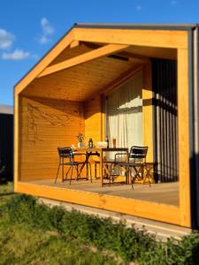 a pavilion with a table and chairs on a deck at 402 Helles Tiny House im Grünen in Bleckede