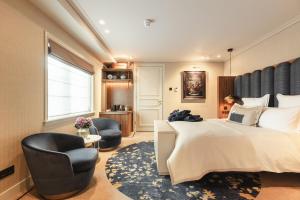 a bedroom with a large bed and two chairs at Hotel 717 in Amsterdam