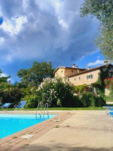 a swimming pool in front of a house and a building at Il rovero in Castion Veronese