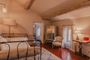 une chambre avec un lit, une chaise et un miroir dans l'établissement La Maison du Village, à Saint-Rémy-de-Provence