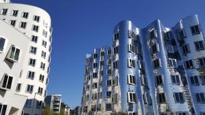 un edificio blu di fronte a due edifici bianchi di Apartment H2 Düsseldorf a Dusseldorf