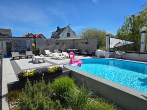 a swimming pool with a pink flamingo in a yard at Domki-Apartamenty Polanki 2 - Sauna, Jacuzzi, Podgrzewany Basen in Łeba