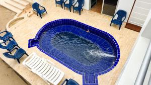 an overhead view of a swimming pool with blue chairs and chairs at Cabaña Costa de Oro in San Antero +27 photos