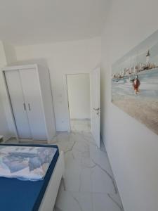 pokój z białymi szafkami i widokiem na plażę w obiekcie Apartmani Totić w mieście Malinska +37 zdjęć