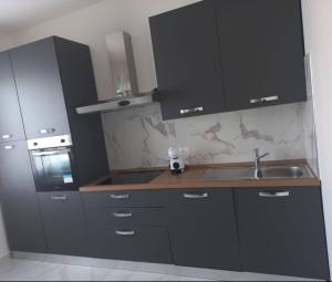 a kitchen with black cabinets and a sink at Luxury Home in Volta Mantovana