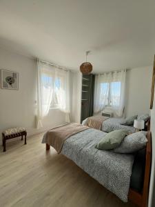 two beds in a bedroom with two windows at La maison d'Alice in Sarlat-la-Canéda