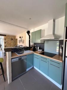 a kitchen with blue cabinets and a stove top oven at La maison d'Alice in Sarlat-la-Canéda