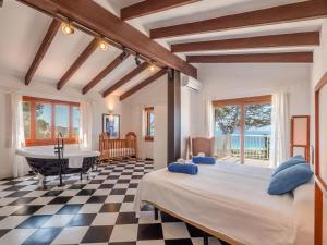 a bedroom with a large bed and a checkerboard floor at Villa Armonia in Son Bou
