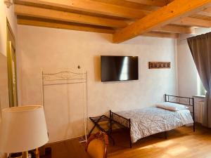 a bedroom with a bed and a tv on the wall at La Casina in Dello