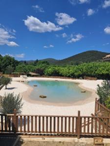 科尔比斯Slow Village Anduze - Cévennes的海滩上的游泳池，旁边是木栅栏