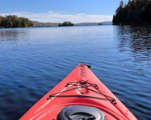 a red kayak on a large body of water at Waterfront Luxury, Sauna, Dock, Lake Access in Saint-Aimé-Du-Lac-des-Îles +44 photos