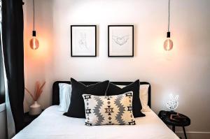 a bedroom with a bed with black and white pillows at Waterfront Luxury, Sauna, Dock, Lake Access in Saint-Aimé-Du-Lac-des-Îles