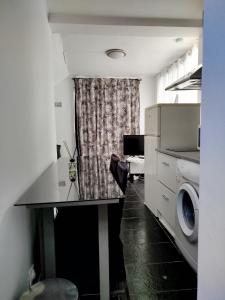 a kitchen with a table and a washing machine at Appartement individuel dans charmante maison de ville à la française in Gagny +4 photos