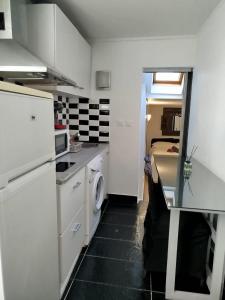 a kitchen with white cabinets and a washer and dryer at Appartement individuel dans charmante maison de ville à la française in Gagny