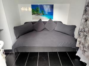 a couch with pillows in a living room at Appartement individuel dans charmante maison de ville à la française in Gagny