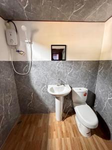a bathroom with a toilet and a sink at Nay Carmen Pension House Port Barton in Itaytay +54 photos