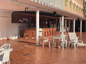 a group of chairs and tables and an umbrella on a patio at Cavalinho Branco 215 in Águas de Lindóia