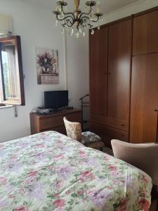 a bedroom with a bed and a cabinet and a chandelier at Casa lorella in Santa Fiora