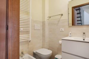 Un baño con inodoro, lavabo y espejo. en Casa Careggine, en Careggine