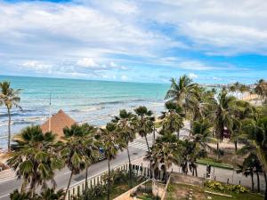 a view of a beach with palm trees and the ocean at Residencial Loft - Studio -407 in Maceió