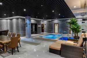 - une piscine dans une pièce avec une table et des chaises dans l'établissement HUSMA Hotel & Spa, à Tachkent