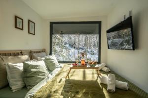 a bedroom with a bed and a table in front of a window at Tiny House 4 Two in Văliug