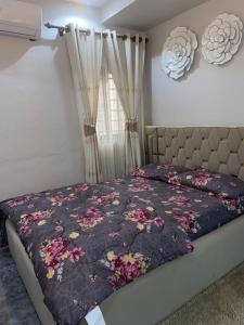 Un dormitorio con una cama con un edredón floral. en Chic Haven cabin, en Trofwi