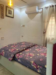 Una cama en una habitación con flores. en Chic Haven cabin, en Trofwi 6 fotos más